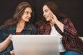 Two young girls or women laughing and discussing something using laptop, female lesbian couple spend time together Royalty Free Stock Photo