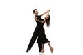 Two young graceful dancers wearing black stage outfits dancing ballroom dance isolated on white background. Concept of Royalty Free Stock Photo