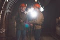 Two young guys in special clothes and helmets standing in the mine