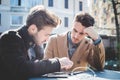 Two young handsome businessmen using tablet