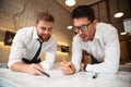 Two young handsome businessmen working on a business plan