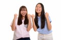 Two young happy Asian teenage girls smiling and both looking mot Royalty Free Stock Photo