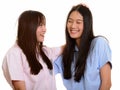 Two young happy Asian teenage girls smiling and patting her frie