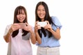 Two young happy Asian teenage girls smiling and taking picture w Royalty Free Stock Photo