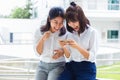 Two young happy Asian women having fun playing social media game