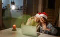 Two young happy beautiful women girlfriends lesbian couple with glasses of champagne in red santa hats celebrate new Royalty Free Stock Photo