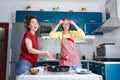 Two young happy caucasian women cook in the kitchen and have fun together. Indoors. Concept of joint home cooking for Royalty Free Stock Photo