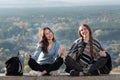 Two young happy girl sitting on the background of nature. Thumbs up. Friendship. Front view Royalty Free Stock Photo