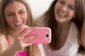 Two young happy girlfriends taking selfie with smart phone. Royalty Free Stock Photo