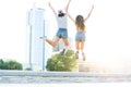 Two young happy hipster girls having fun, smiling, laughing, jumping, walking outdoor on the street, summer relax