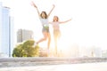 Two young happy hipster girls having fun, smiling, laughing, jumping, walking outdoor on the street, summer relax