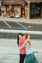 Two sisters hugging in the street
