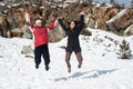 Two young happy teenage girls jumping with pleasure at snow Royalty Free Stock Photo