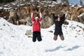 Two young happy teenage girls jumping with pleasure at snow Royalty Free Stock Photo