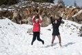 Two young happy teenage girls jumping with pleasure at snow Royalty Free Stock Photo