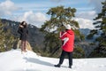 Two young happy teenage taking photos with a mobile phone on a snowy mountain