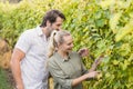 Two young happy vintners looking at grapes Royalty Free Stock Photo