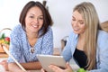 Two young happy women are making online shopping by tablet computer and credit card. Friends are going to cook in the Royalty Free Stock Photo