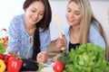 Two young happy women are making online shopping by tablet computer and credit card. Friends are going to cook in th Royalty Free Stock Photo