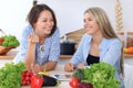 Two young happy women are making online shopping by tablet computer and credit card. Friends are going to cook in th