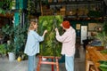 Two young hipster designers working on floral collage at florist shop Royalty Free Stock Photo