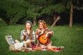 Two young hipster girls having fun on the picnic Royalty Free Stock Photo