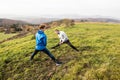 Two young hipster runners in sunny autumn nature stretching legs Royalty Free Stock Photo