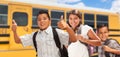 Happy Young Hispanic Boys and Girl Walking Near School Bus