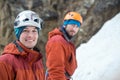 Two young ice climbers in sport helmets looking at us on ice background Royalty Free Stock Photo
