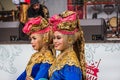 Two young Indonesian women in traditional clothes stand near the stage