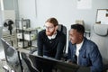 Two young intercultural diversity programmers looking at compute screen