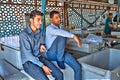 Two young Iranians are resting at entrance to fish market.