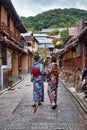 Two young Japanese girls in kimono walking along the street of Gion. Kyoto. Japan