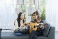 Two young ladies playing kalimba and guitar in the living room Royalty Free Stock Photo