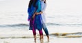 Two young ladies standing around the beach water unique photo