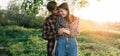 Two young laughing people are hugging in the park in nature. Happy family in casual clothes. Romantic meeting. Love and