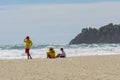 Two young lifeguards and a boy sit on hazy beach watch the rough dangerous surf