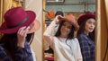 Two young lovely women trying on hats, while shopping together