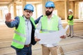 Two young male engineers discussing project details on a construction site Royalty Free Stock Photo