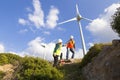 Young engineers looking and checking wind turbines at field Royalty Free Stock Photo