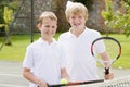 Two young male friends on tennis court Royalty Free Stock Photo