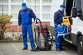 Two Male Janitor Unloading Cleaning Equipment From Vehicle Royalty Free Stock Photo