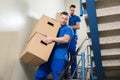 Two Movers Carrying Cardboard Boxes On Staircase Royalty Free Stock Photo