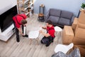 Two Male Mover Wrapping Furniture For Moving Royalty Free Stock Photo