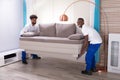 Two Male Movers Placing The Sofa