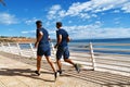 Two young mans is running along tne beach