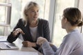 Two young and mature business colleagues women talking at table Royalty Free Stock Photo