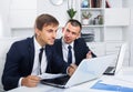 Two young men coworkers working in firm office Royalty Free Stock Photo