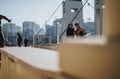 Two young men enjoying a bright sunny day on urban rooftop with cityscape in background.