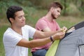 Two young men erecting tent